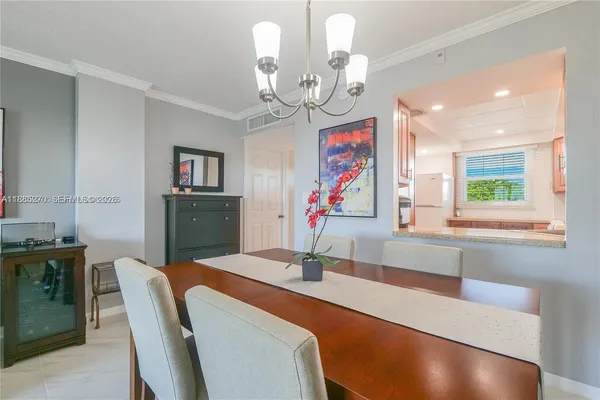 a dining room with wooden floor a chandelier a wooden table and chairs
