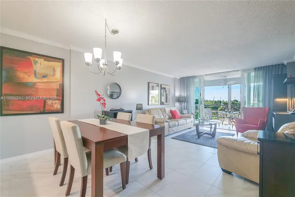a view of a dining room with furniture a chandelier and wooden floor
