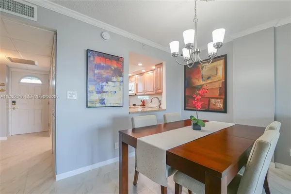a view of a dining room with furniture a chandelier and wooden floor