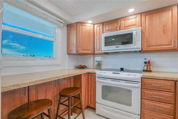 a kitchen with stainless steel appliances granite countertop a sink and cabinets with wooden floor