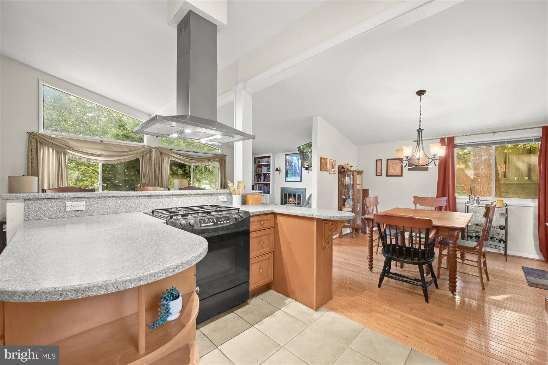 9233 Spring Valley Road Ellicott City, MD 21043 - Photo 10 of 45 a kitchen with stainless steel appliances granite countertop a stove top oven a sink a dining table and chairs with wooden floor