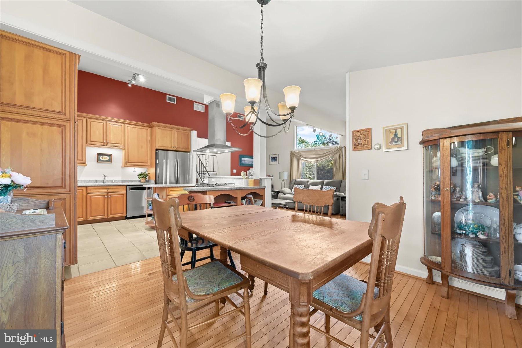 9233 Spring Valley Road Ellicott City, MD 21043 - Photo 11 of 45 a view of a dining room and livingroom with furniture wooden floor a rug a painting and a chandelier