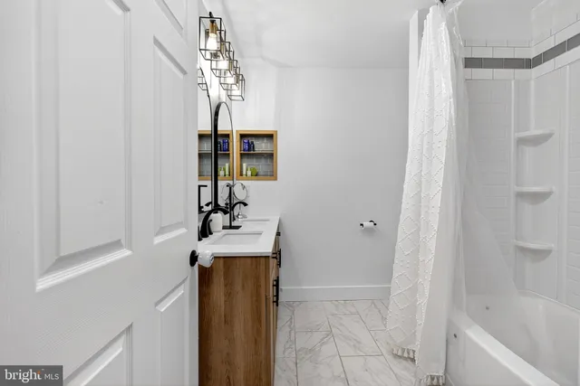 a bathroom with a sink a mirror and shower