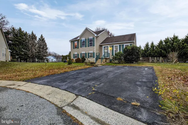 a front view of a house with a yard and trees