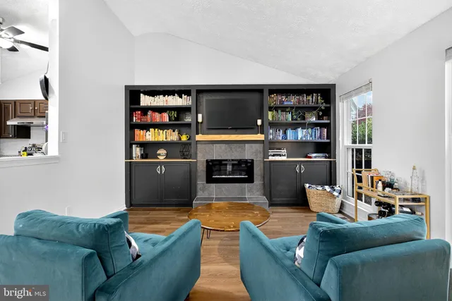 a living room with furniture a fireplace and a flat screen tv