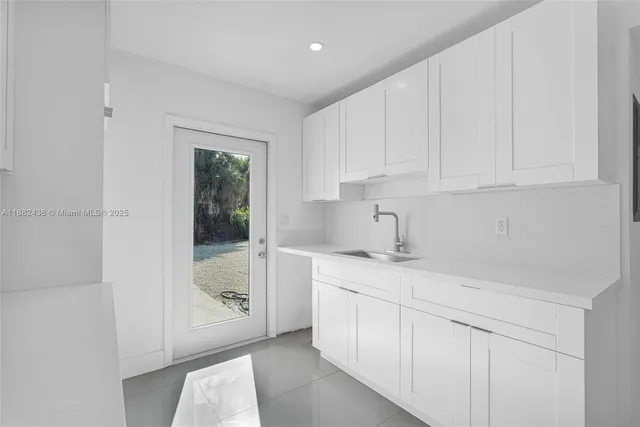 a kitchen with granite countertop white cabinets and white appliances