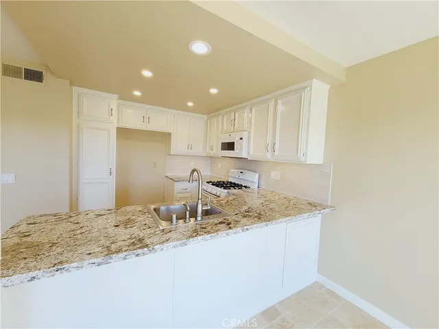 a view of a kitchen with a sink and a refrigerator