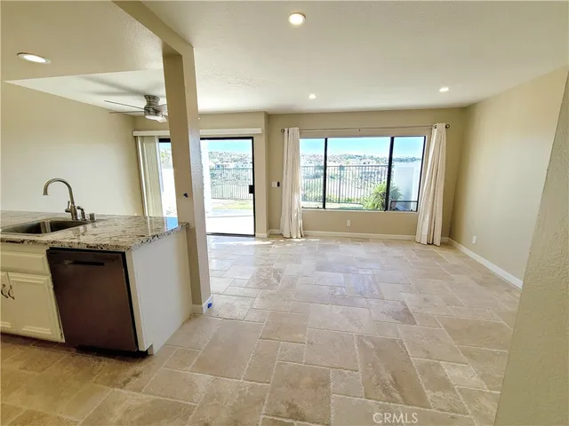 an empty room with chandelier fan and window