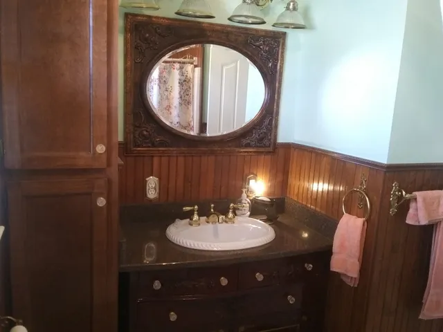 a bedroom with a bed and a mirror on dresser