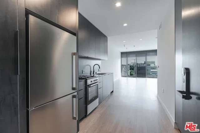 a large kitchen with a sink and stainless steel appliances