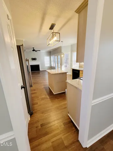 a kitchen with a sink a refrigerator a window and cabinets