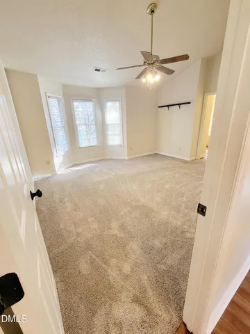 an empty room with a window and a fan