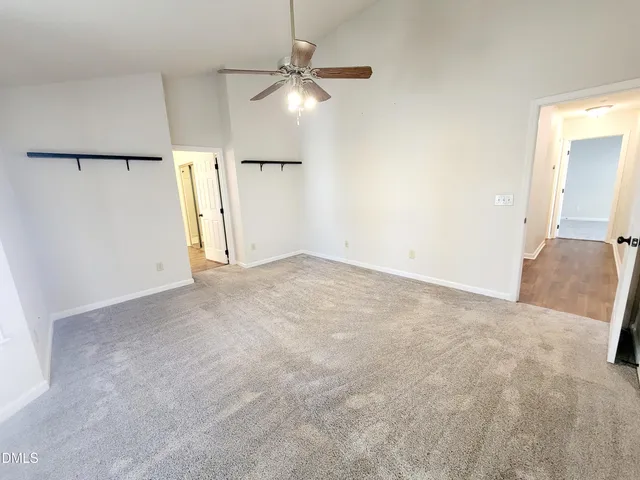 an empty room with a chandelier fan