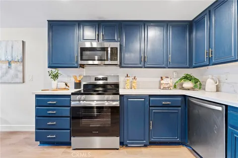 a kitchen with stainless steel appliances granite countertop wooden cabinets a stove top oven a sink and dishwasher