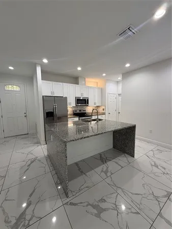 a kitchen with stainless steel appliances granite countertop a sink and a stove
