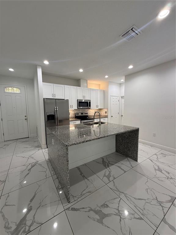 310 Grape Avenue St. Cloud, FL 34769 - Photo 12 of 27 a kitchen with stainless steel appliances granite countertop a sink and a stove