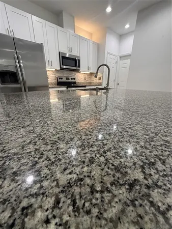 a kitchen with kitchen island a sink stainless steel appliances and cabinets