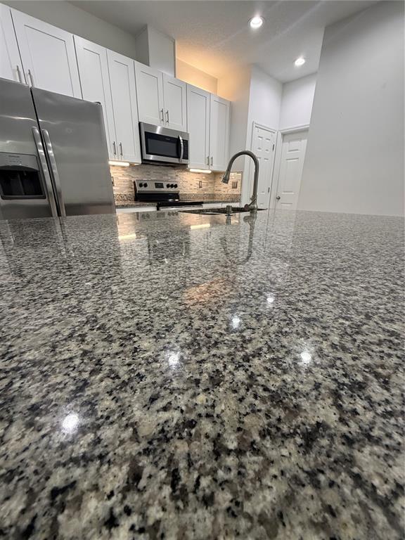 310 Grape Avenue St. Cloud, FL 34769 - Photo 13 of 27 a kitchen with kitchen island a sink stainless steel appliances and cabinets