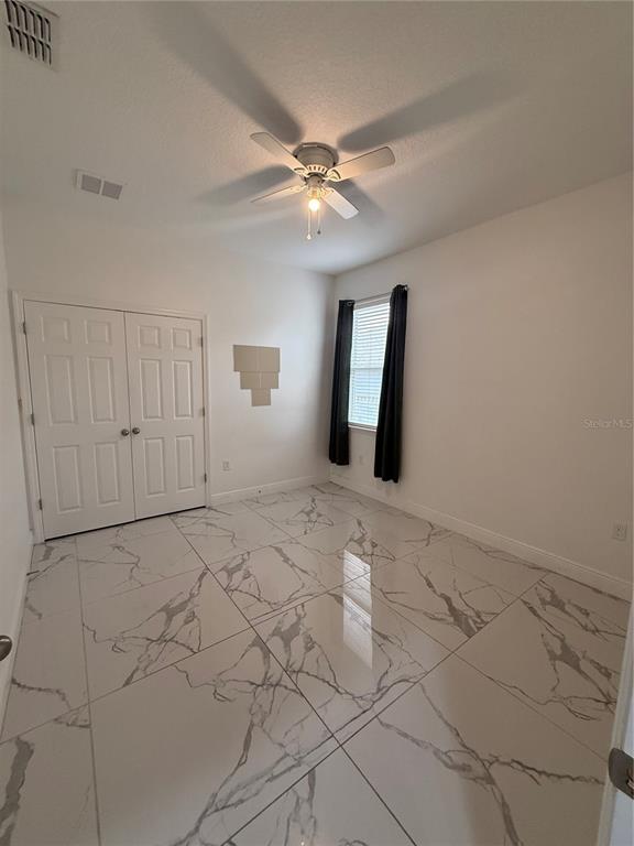310 Grape Avenue St. Cloud, FL 34769 - Photo 23 of 27 a view of an empty room with window and chandelier fan