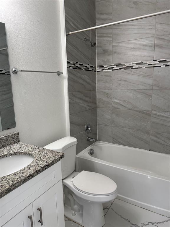 310 Grape Avenue St. Cloud, FL 34769 - Photo 25 of 27 a bathroom with a granite countertop sink toilet and shower