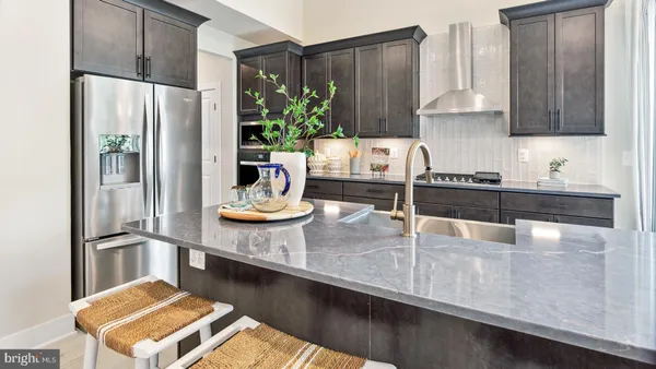 a kitchen with granite countertop a refrigerator a stove and a sink