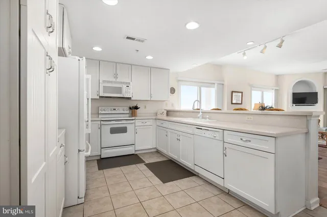 a kitchen with white cabinets and white appliances