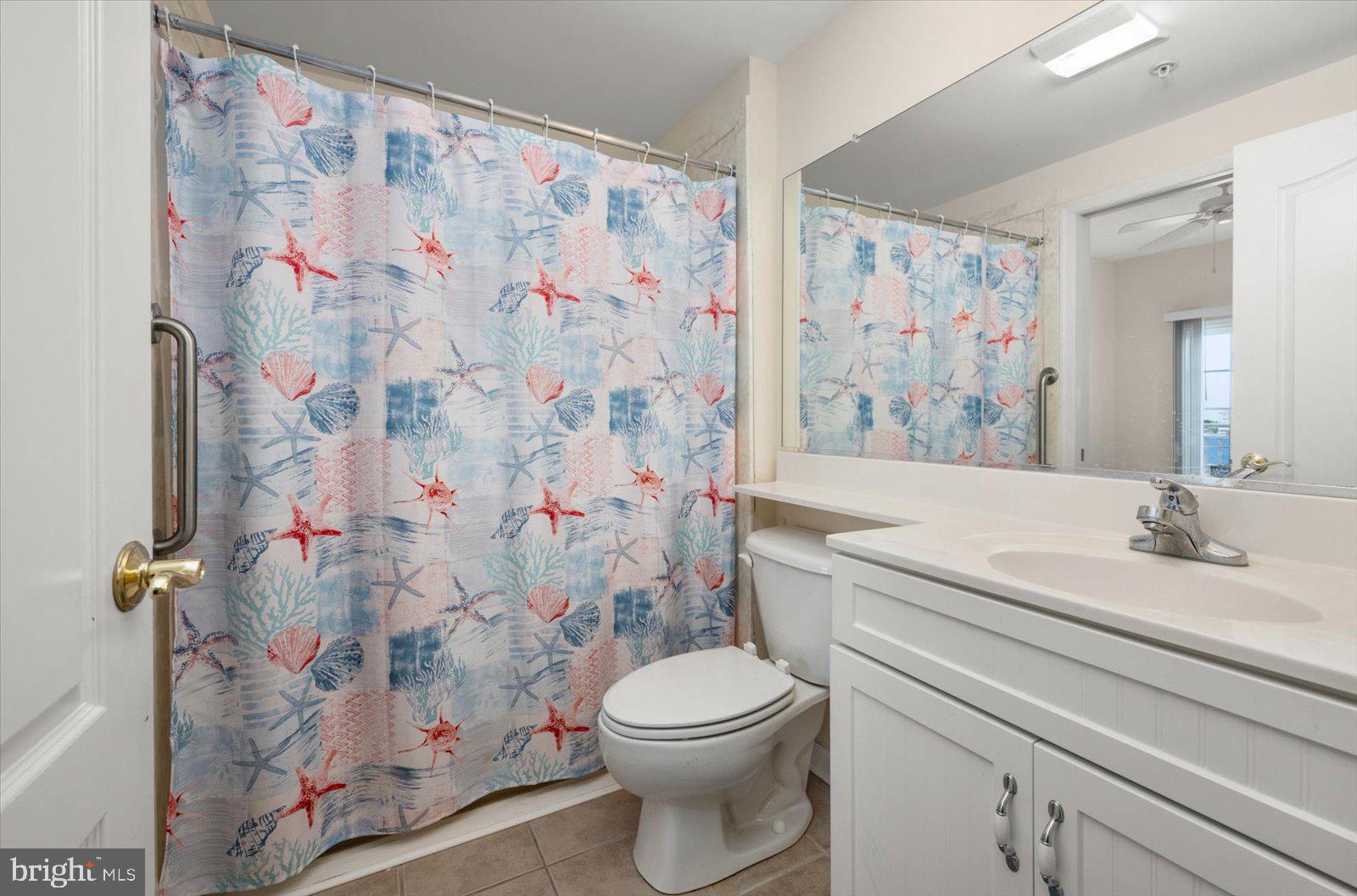 102 Williams Street, Unit 311 Crisfield, MD 21817 - Photo 25 of 57 a bathroom with a toilet sink and a shower curtain