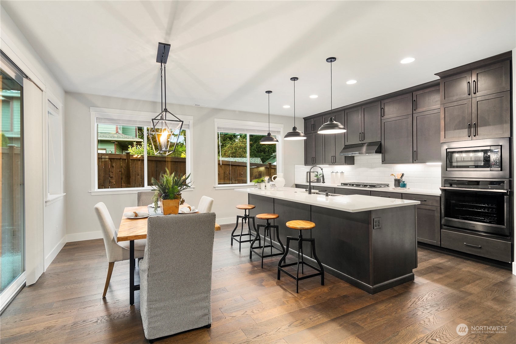 1303 197th Place Southeast Bothell, WA 98012 - Photo 4 of 34 a kitchen with stainless steel appliances granite countertop a stove top oven a sink dishwasher a dining table and chairs with wooden floor