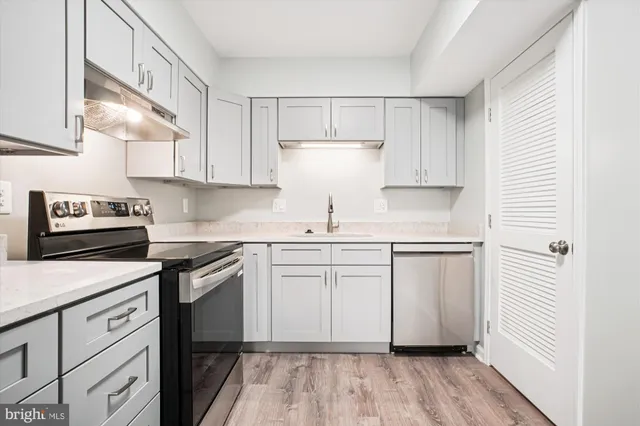 a kitchen with granite countertop white cabinets and white appliances