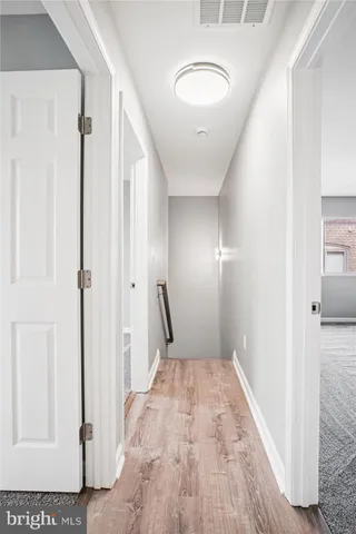 a view of a hallway with wooden floor and staircase
