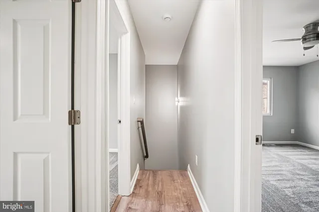 a view of a hallway with wooden floor and staircase