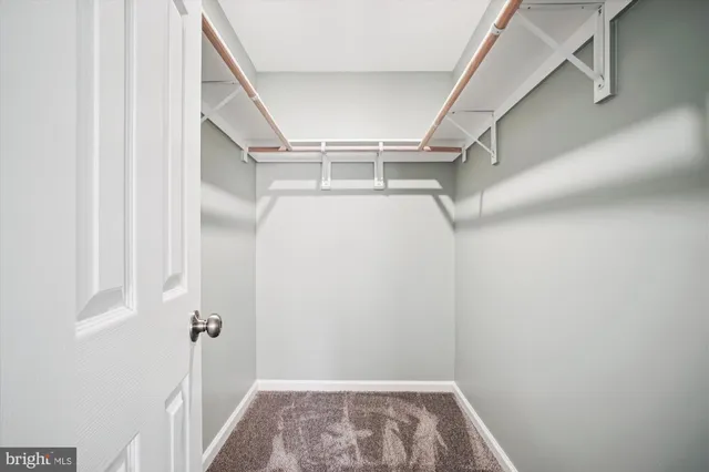 a view of walk in closet with empty racks