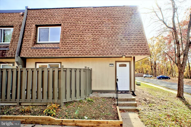 a view of a brick house with wooden fence
