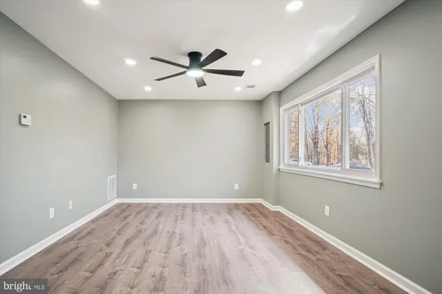 a view of a big room with wooden floor and windows