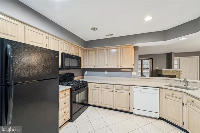 a kitchen with white cabinets stainless steel appliances and a sink