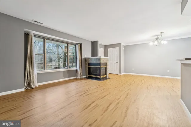 a view of empty room with wooden floor and fireplace