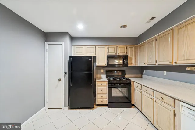 a kitchen with a refrigerator a stove top oven and cabinets