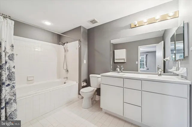 a bathroom with a double vanity sink mirror bathtub and toilet