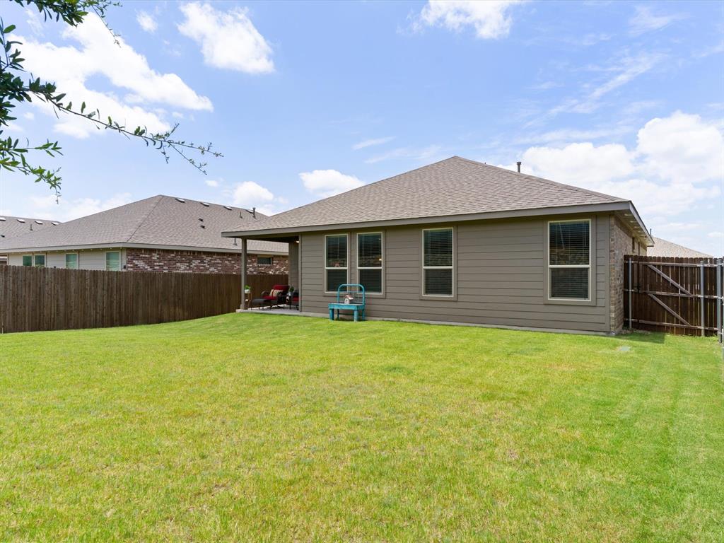 270 Lunayena Road Rhome, TX 76078 - Photo 37 of 37 The backyard offers a spacious outdoor setting with a covered patio, creating an ideal space for outdoor dining, relaxing, or entertaining while enjoying the open Texas landscape.