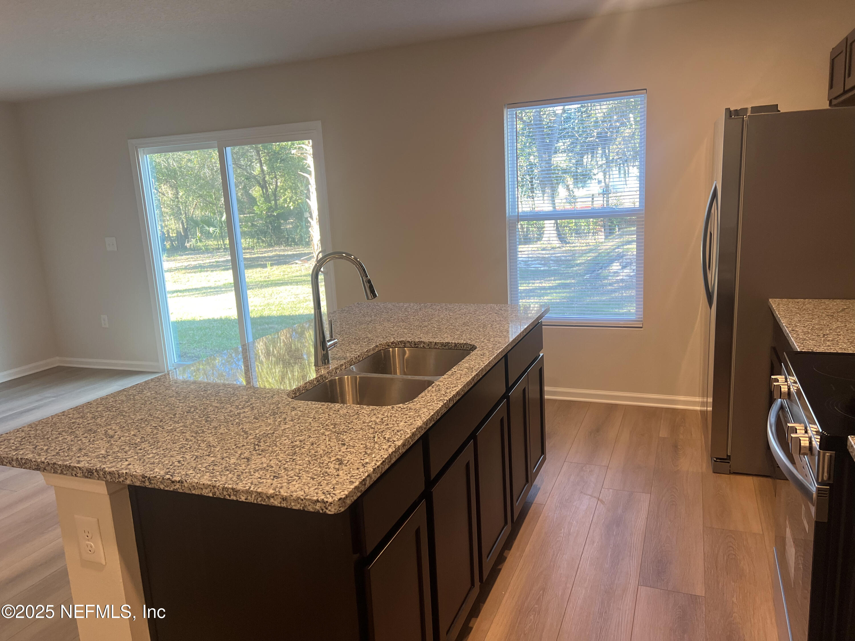 3945 Rose Street Jacksonville, FL 32208 - Photo 9 of 27 a kitchen with stainless steel appliances granite countertop a sink a stove a refrigerator and wooden floor