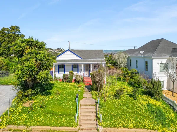 a front view of a house with a yard and potted plants
