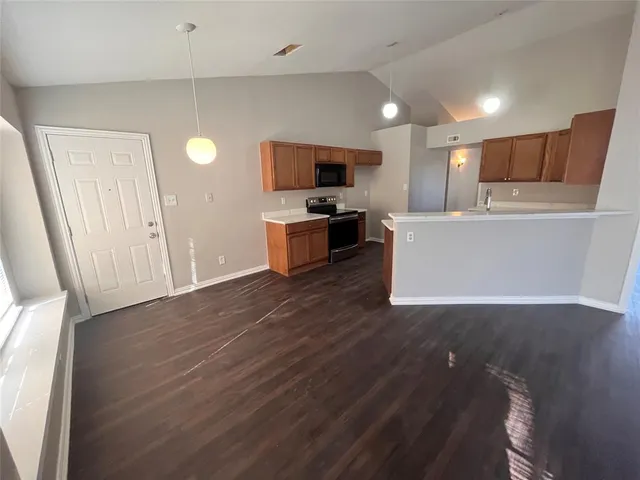 a view of kitchen with microwave a refrigerator and a sink