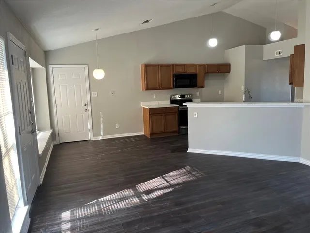a view of a kitchen with wooden floor and electronic appliances
