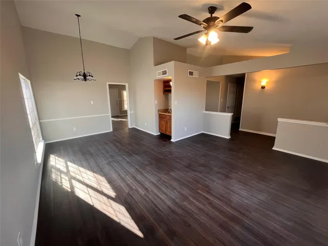 a view of a livingroom with a ceiling fan and wooden floor