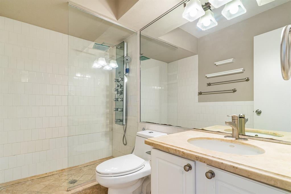 5934 Sandhurst Lane, Unit 207 Dallas, TX 75206 - Photo 17 of 31 a bathroom with a sink a toilet a mirror and shower