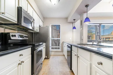 a kitchen with stainless steel appliances sink stove and cabinets