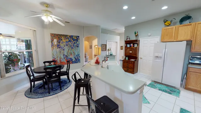 a kitchen with stainless steel appliances granite countertop a table chairs and a refrigerator