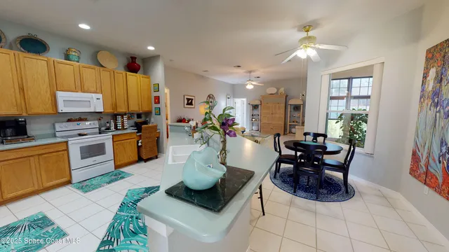 a kitchen with stainless steel appliances kitchen island granite countertop a stove a sink a dining table and chairs with the view of kitchen