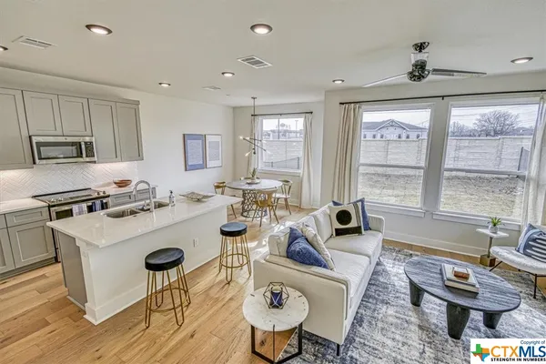 a living room with furniture a large window and a table