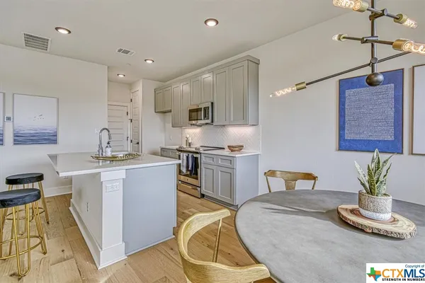 a kitchen with a sink appliances and cabinets